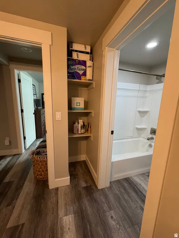 Full 2nd bathroom with a tub/shower combination with storage shelves