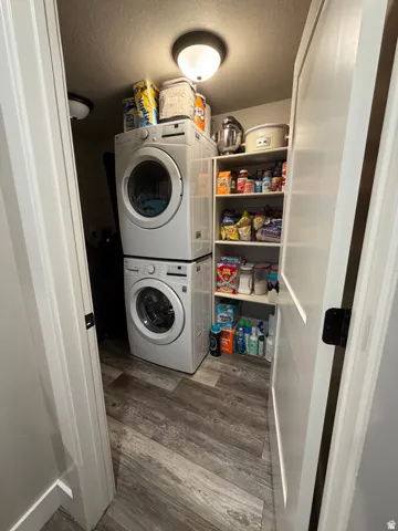 Dedicated laundry area featuring a stacked washer and dryer, and built in shelving.