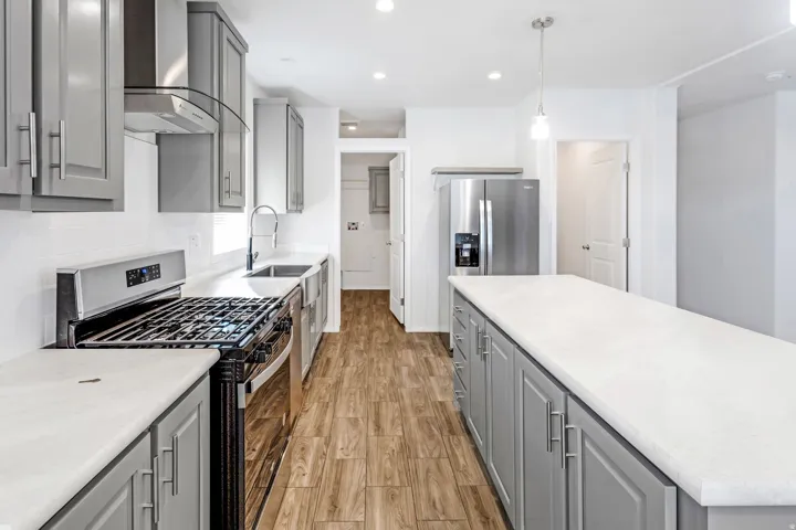 Kitchen featuring wood-finish flooring, recessed lighting, and a center island with a light-colored countertop
