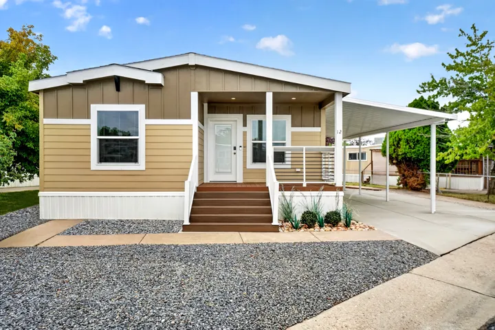 Inviting home exterior featuring multi-toned siding, a covered front porch with dark wood-finish steps, and a white balustrade