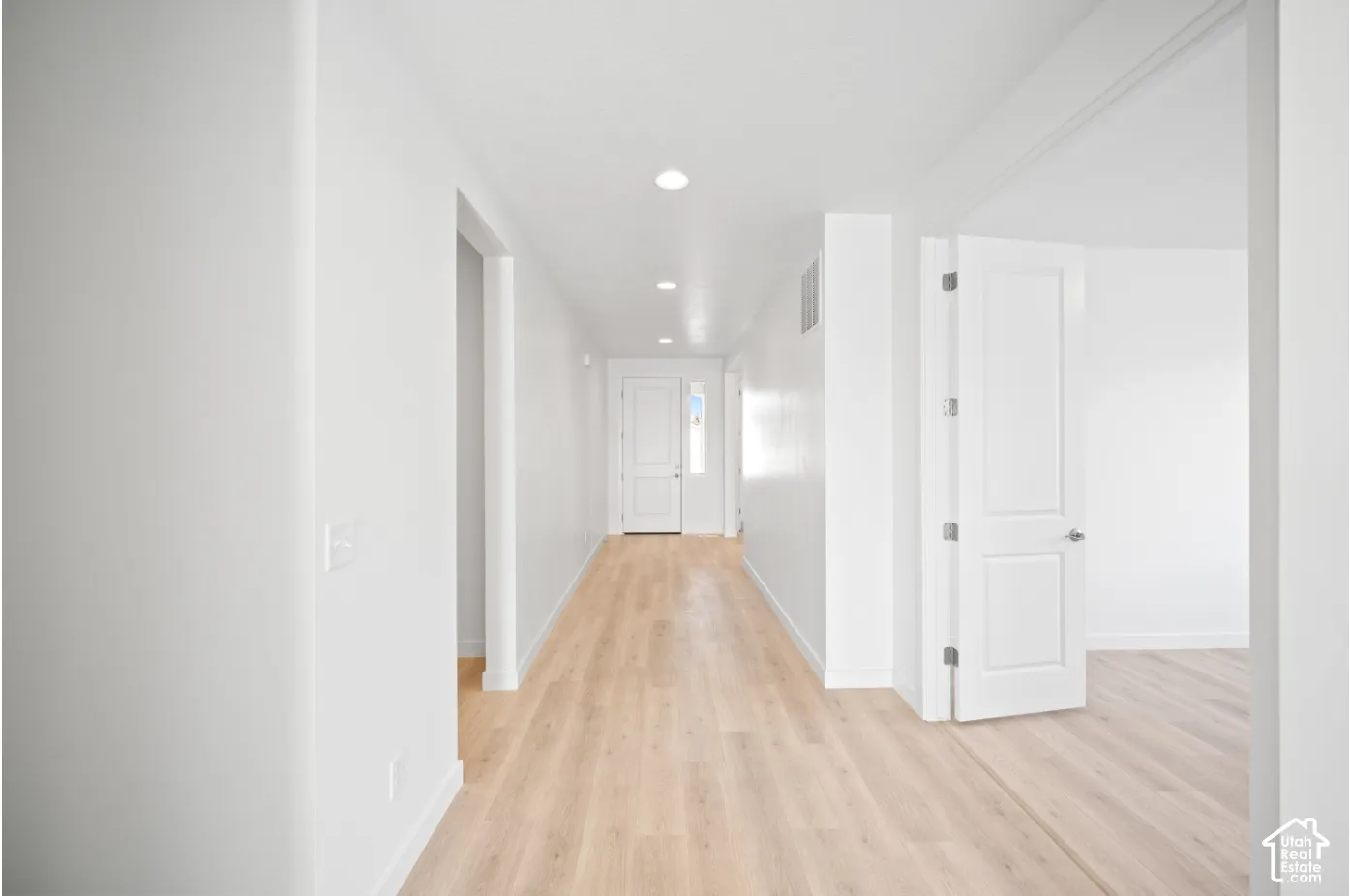 Entryway featuring wood-finish flooring, recessed lighting, and crisp white walls