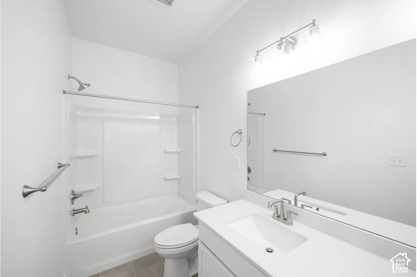 Bathroom featuring a white vanity with an integrated sink, polished chrome faucet, and a large wall mirror