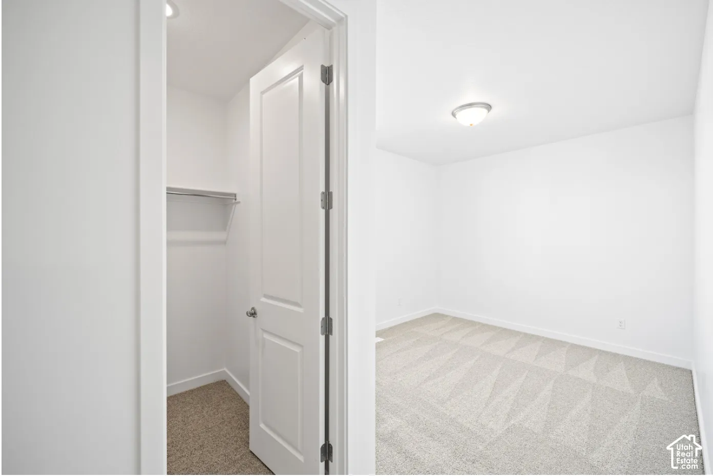 Bright room featuring light-colored patterned carpet and a flush-mount ceiling light fixture