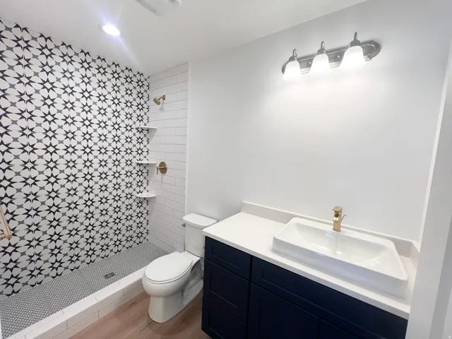 Contemporary bathroom featuring a patterned shower tile wall, a white subway tile surround, and a coordinating mosaic tile shower floor