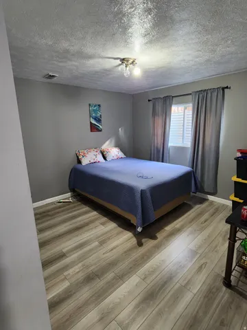 Bedroom with gray painted walls and wood-finish flooring