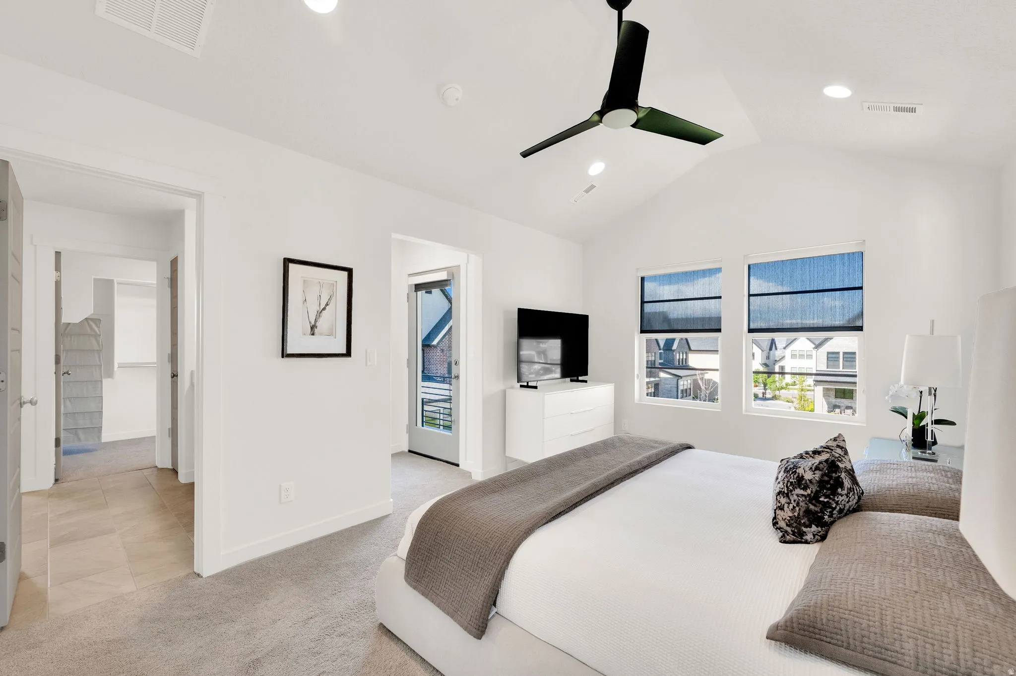Vaulted ceiling bedroom featuring a modern ceiling fan, recessed lighting, carpet flooring, and multiple windows with roller shades