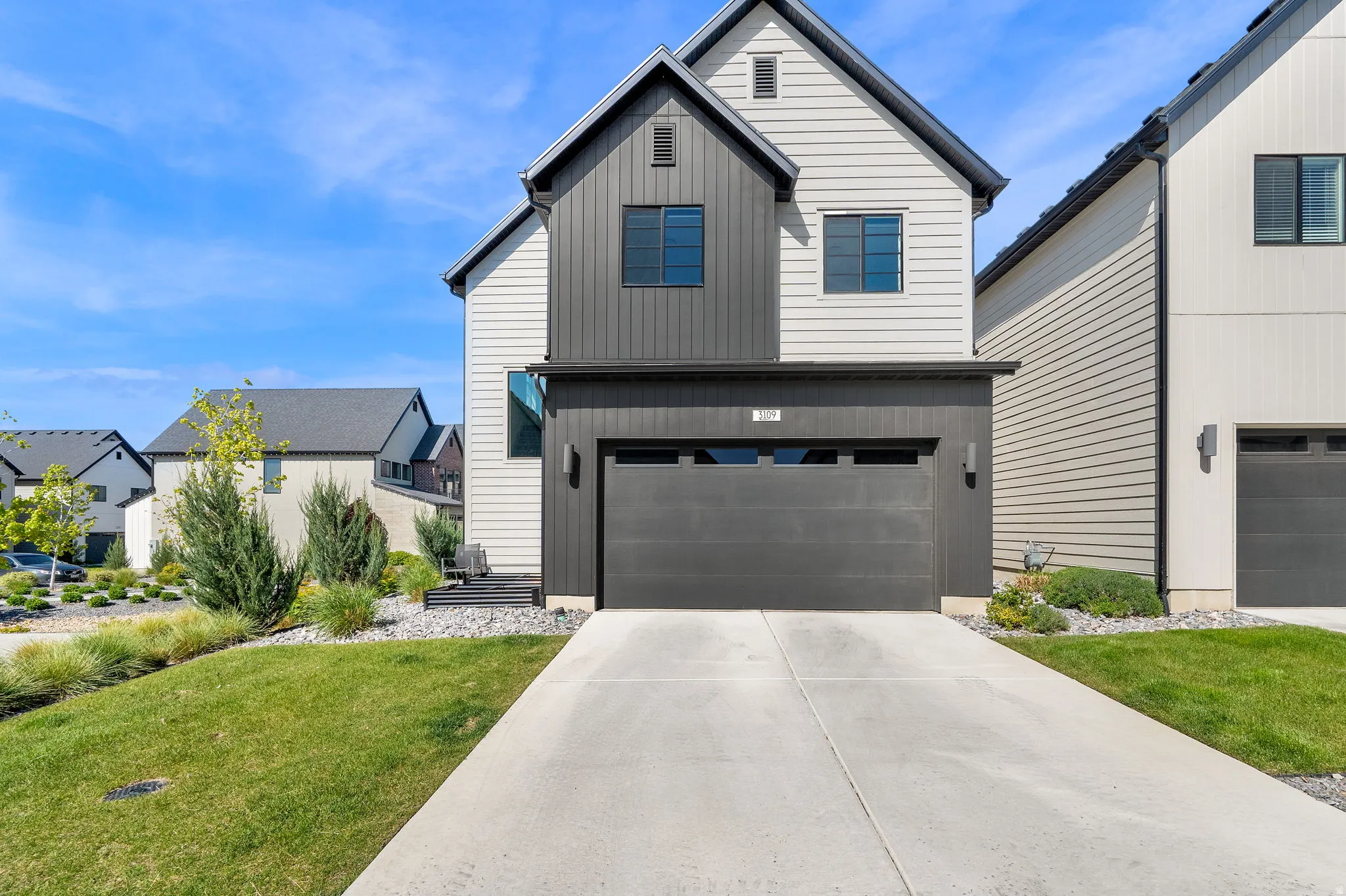 Modern exterior featuring white siding and dark board and batten accents