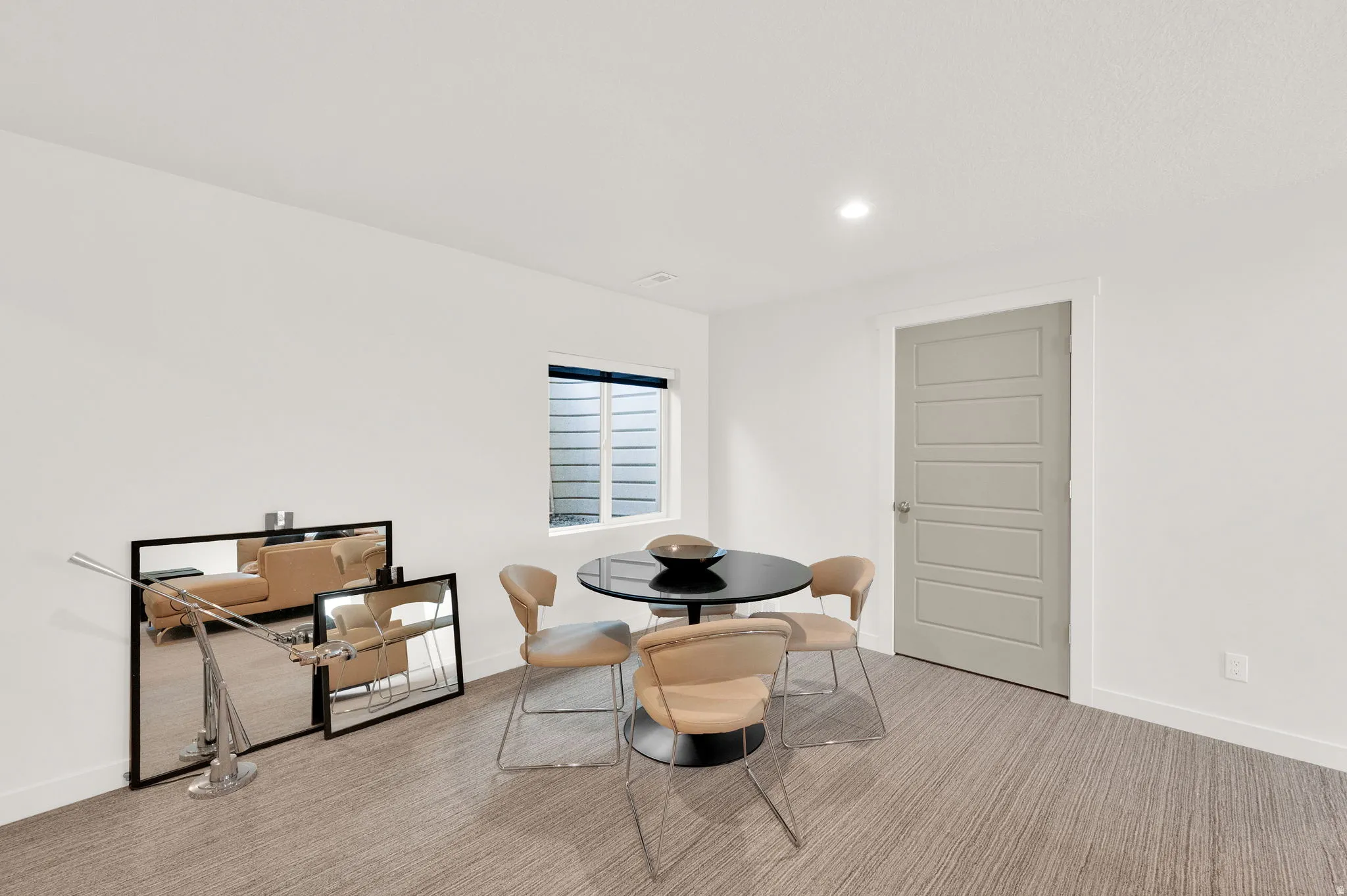 Recessed lighting illuminates neutral walls and textured carpet flooring