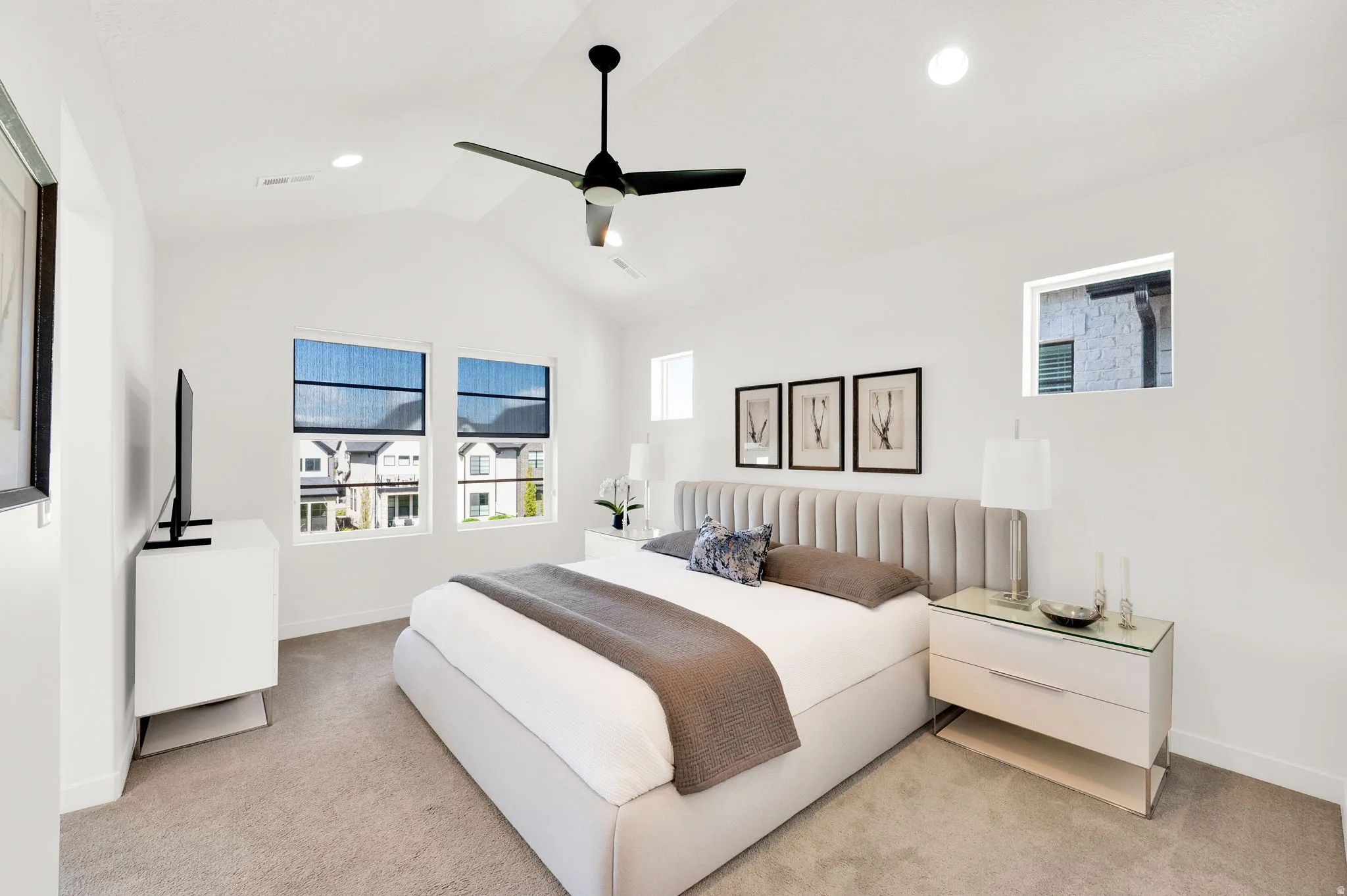 Spacious bedroom featuring vaulted ceilings, recessed lighting, and a contemporary ceiling fan