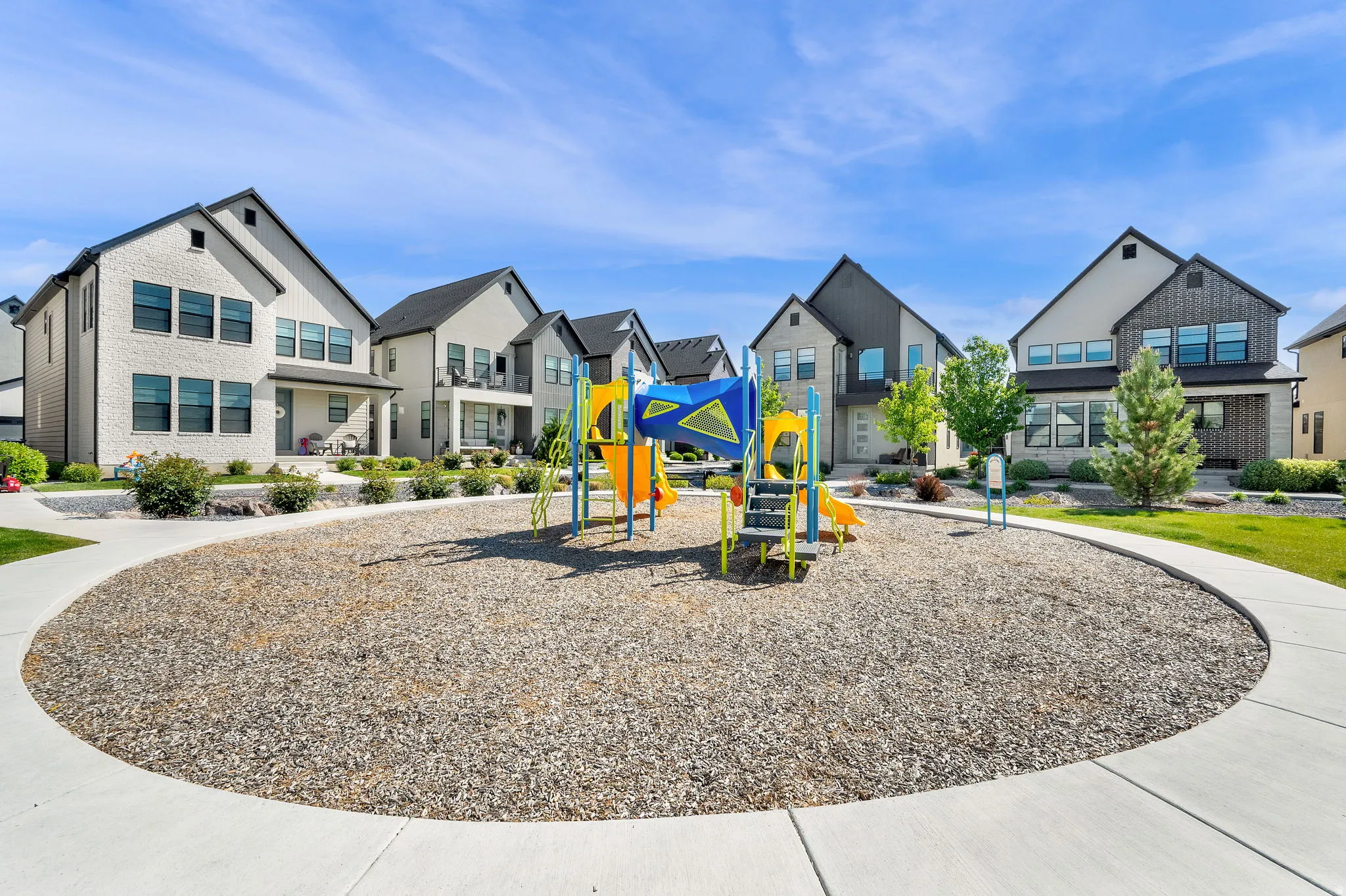 Central playground area featuring a colorful play structure with slides and climbing elements