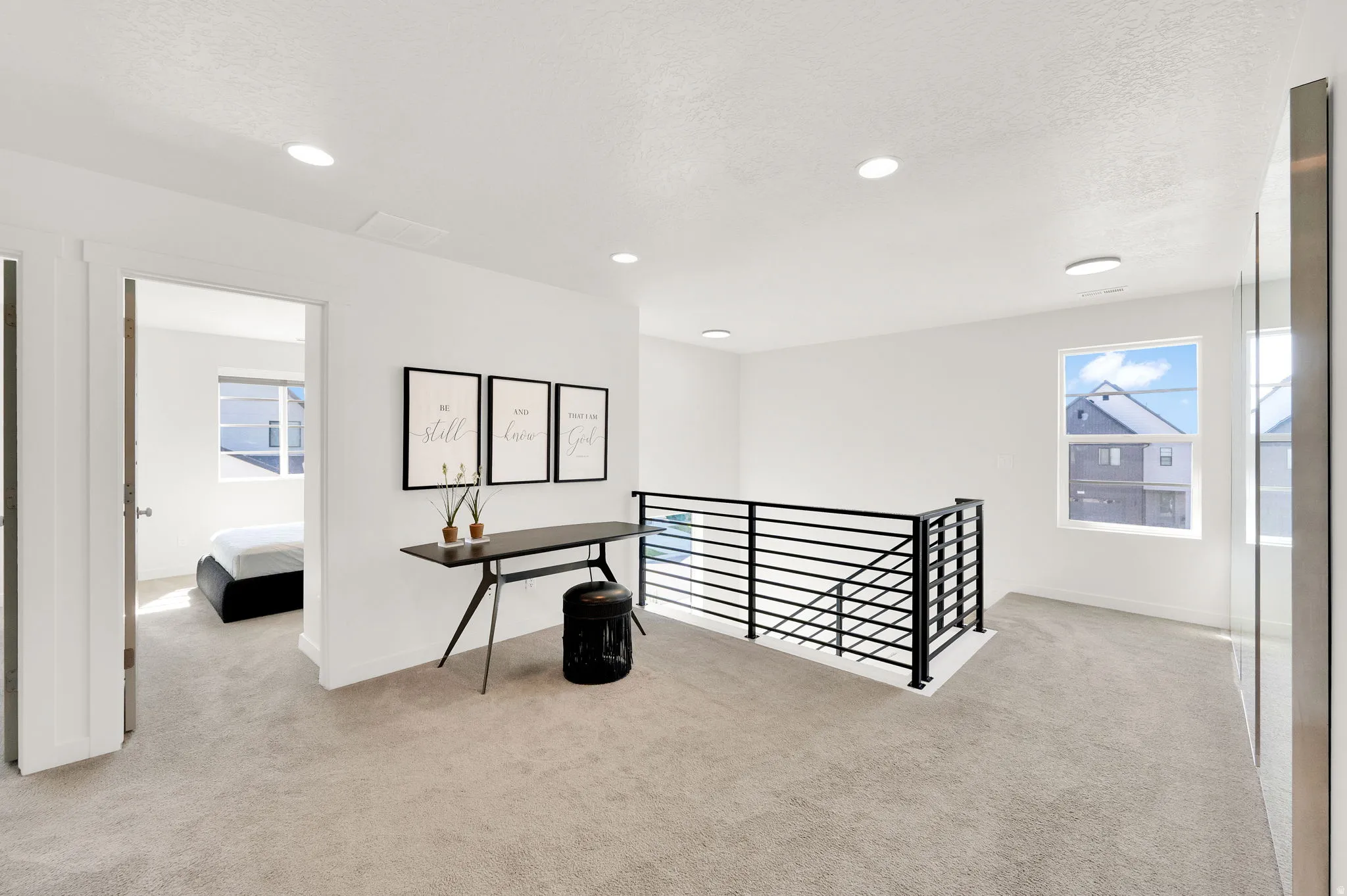 Upper-level landing featuring light-toned carpeting and recessed lighting