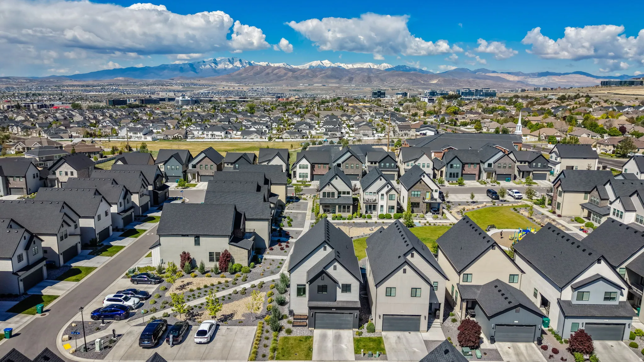Modern residential community featuring varied architectural styles and dark asphalt shingle roofs