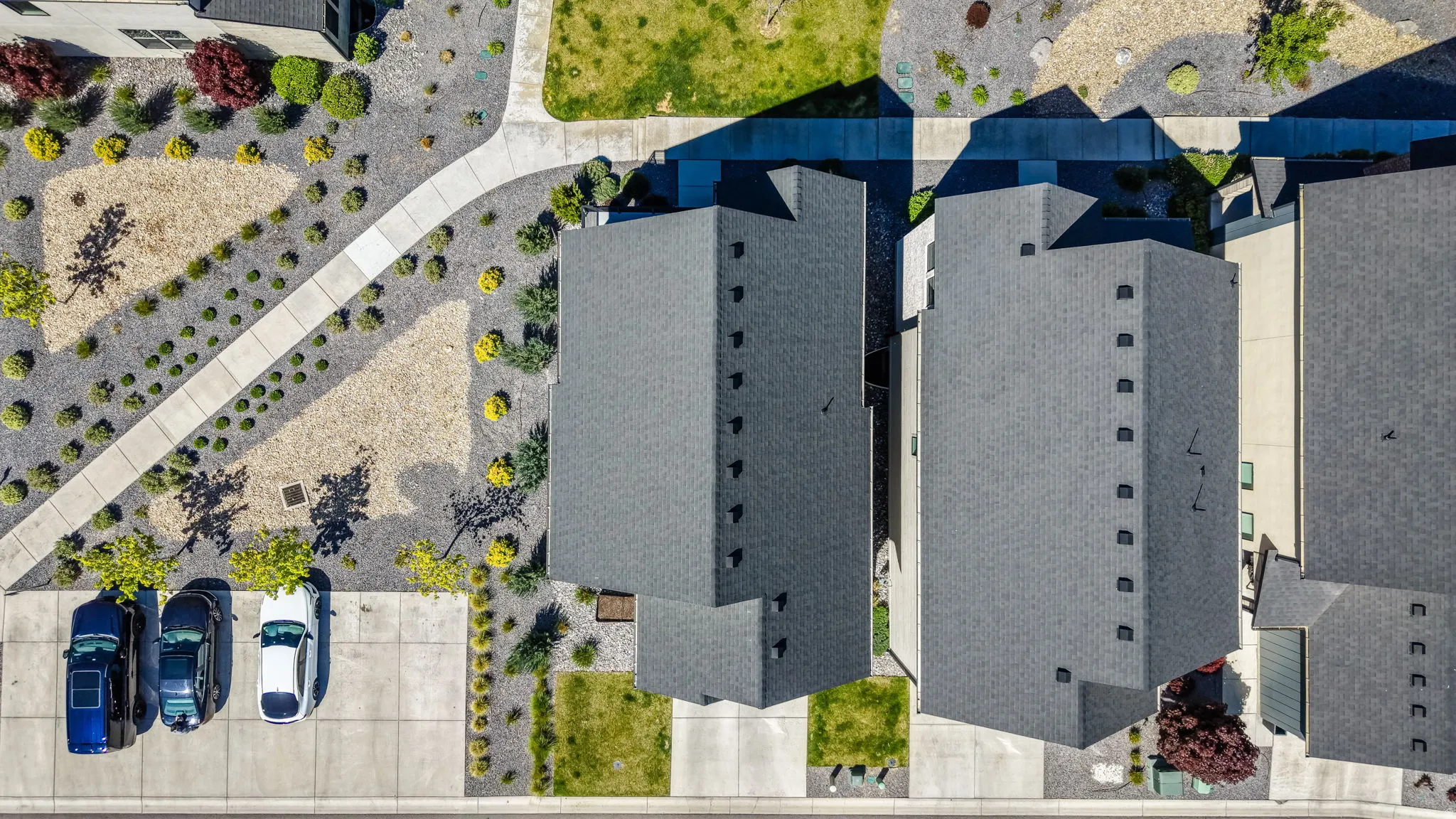 Aerial perspective showcasing multiple properties with gray shingled roofs