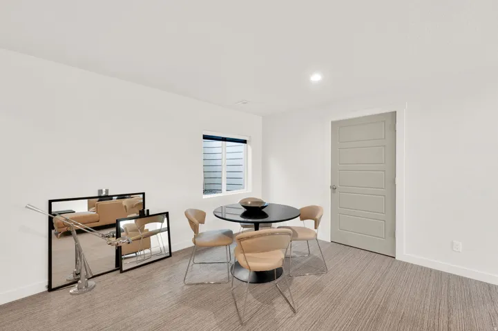 Recessed lighting illuminates neutral walls and textured carpet flooring