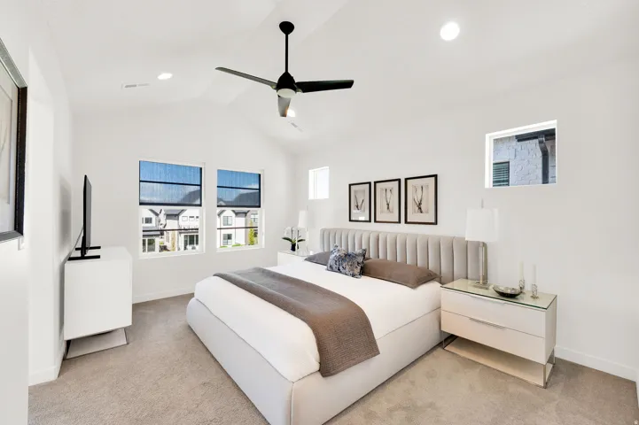 Spacious bedroom featuring vaulted ceilings, recessed lighting, and a contemporary ceiling fan