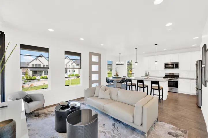 Open-concept living space featuring wood-finish flooring, recessed lighting, and large windows with black trim
