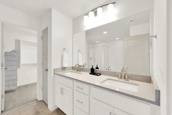 Dual vanity with undermount sinks, speckled stone countertops, and brushed nickel fixtures