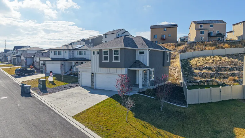 Contemporary two-story residence featuring a two-car garage, gray stucco and white board-and-batten siding