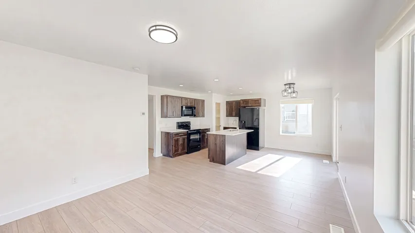 Open-concept living space featuring wood-finish flooring, white walls, and recessed lighting