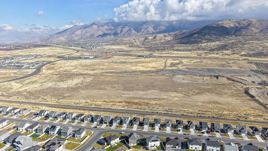 Expansive land parcel featuring distant mountain ranges and established residential developments
