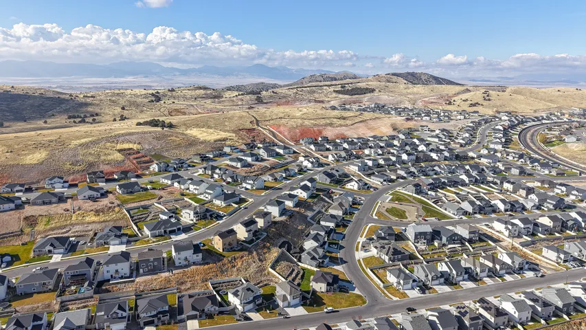 Expansive residential development featuring numerous single-family homes with dark and light gray roofing