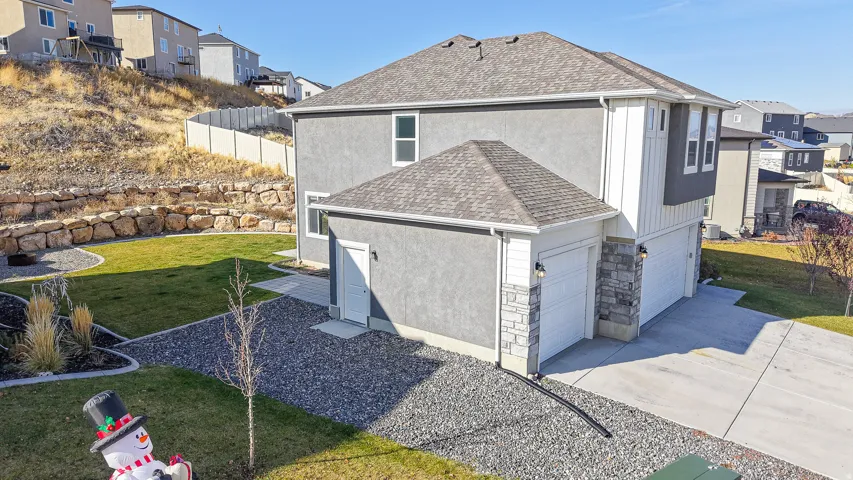 Contemporary stucco exterior with stone accents and multiple garage doors