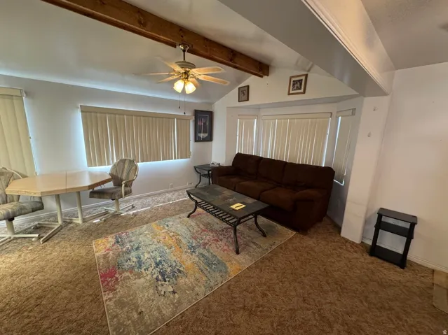 Living area featuring vaulted ceilings with exposed wood beams
