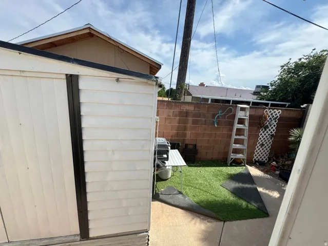 White siding shed with black trim