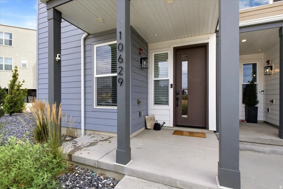 Contemporary exterior featuring a brown entry door with vertical glass insert, white window frames, and grey horizontal siding