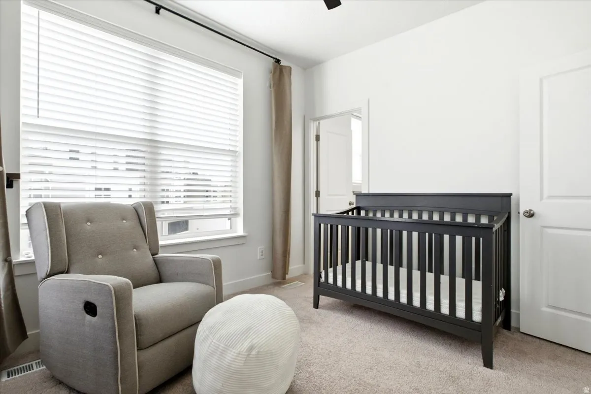 Carpeted room featuring a large window with horizontal blinds and full-height curtains, white painted walls, and white trim