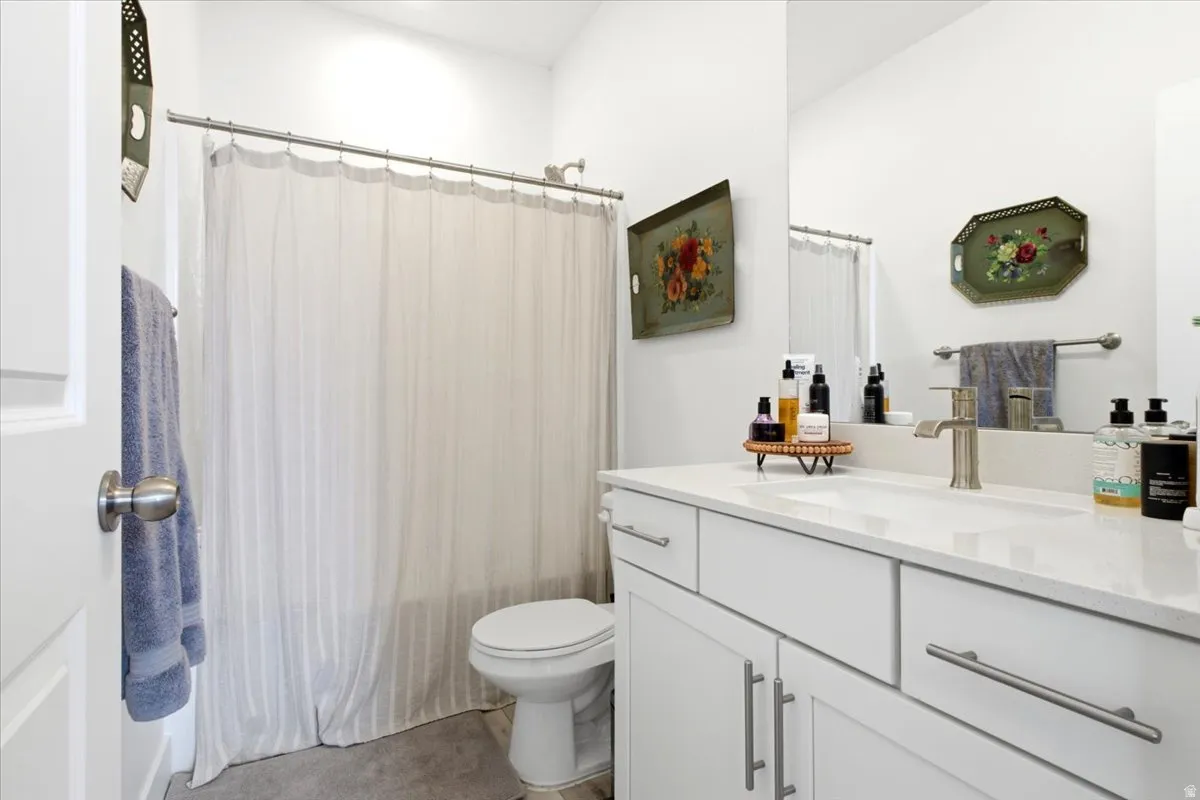 Bright bathroom with a white vanity featuring a rectangular integrated sink and brushed nickel hardware
