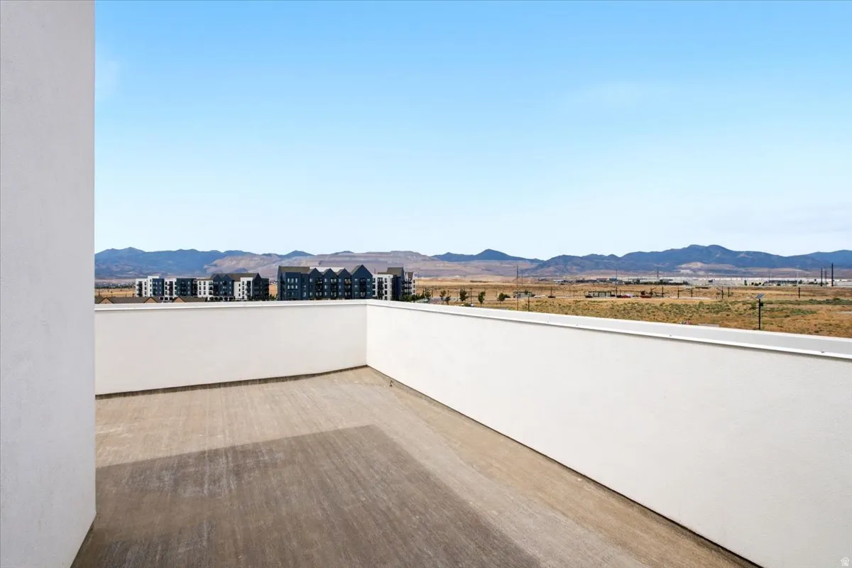 Expansive outdoor terrace featuring concrete flooring and a low privacy wall