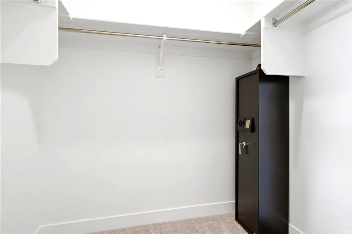 White closet system featuring upper shelving and a metal hanging rod