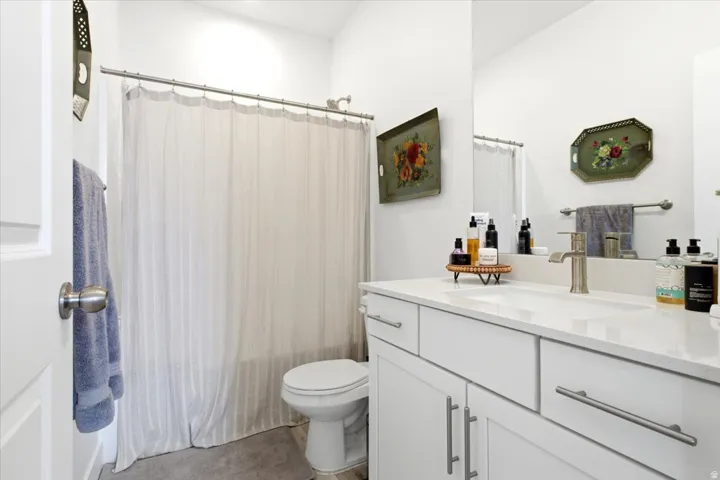 Bright bathroom with a white vanity featuring a rectangular integrated sink and brushed nickel hardware