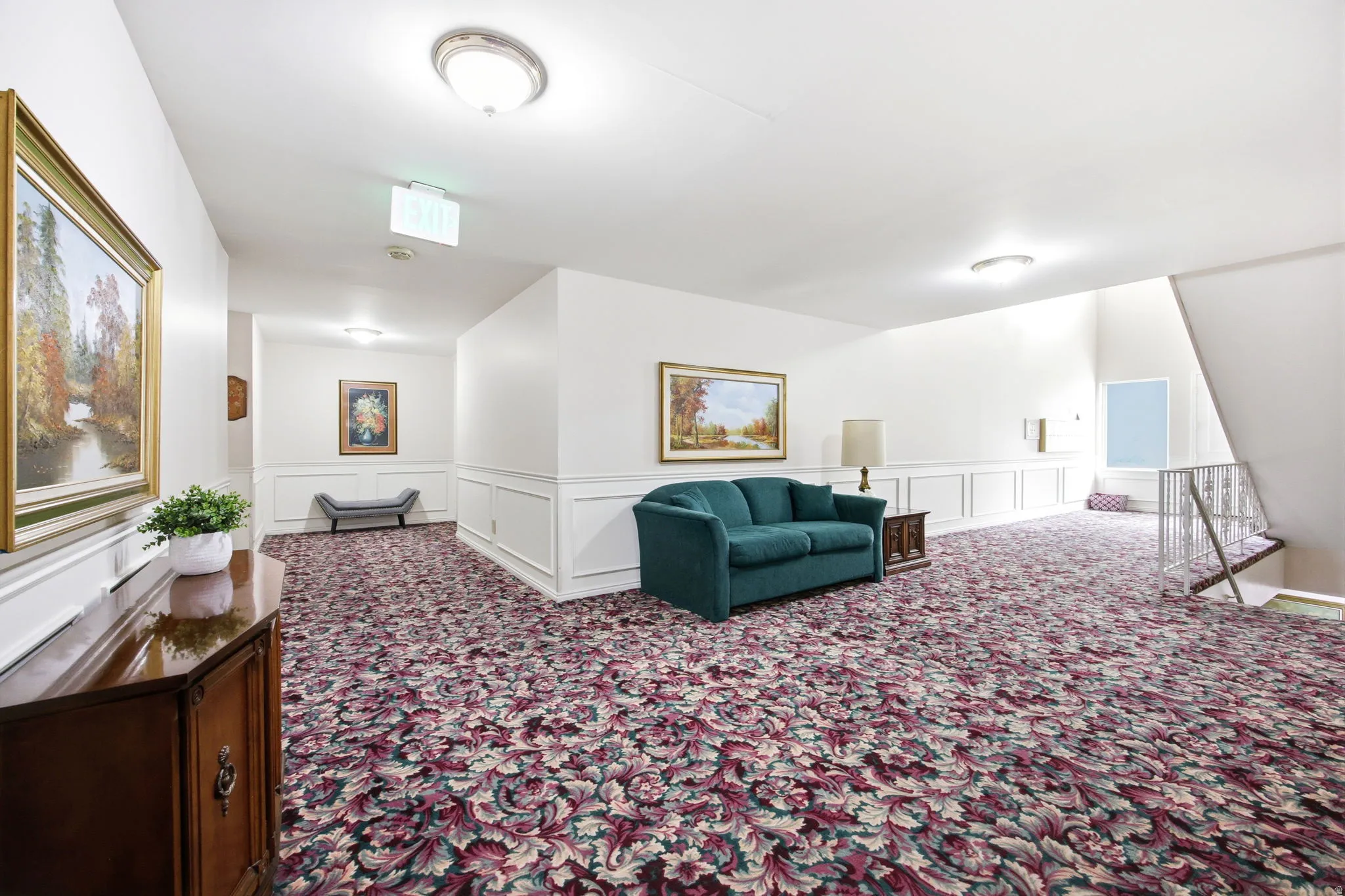 White walls with wainscoting and a patterned carpet flooring