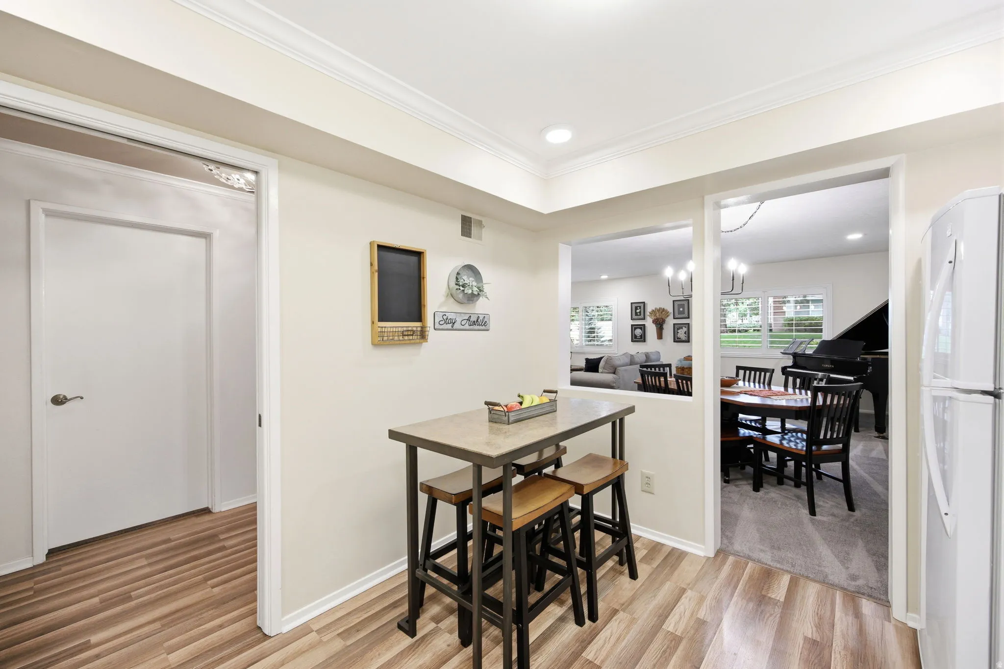 Kitchen area featuring wood-finish flooring, recessed lighting, and crown molding