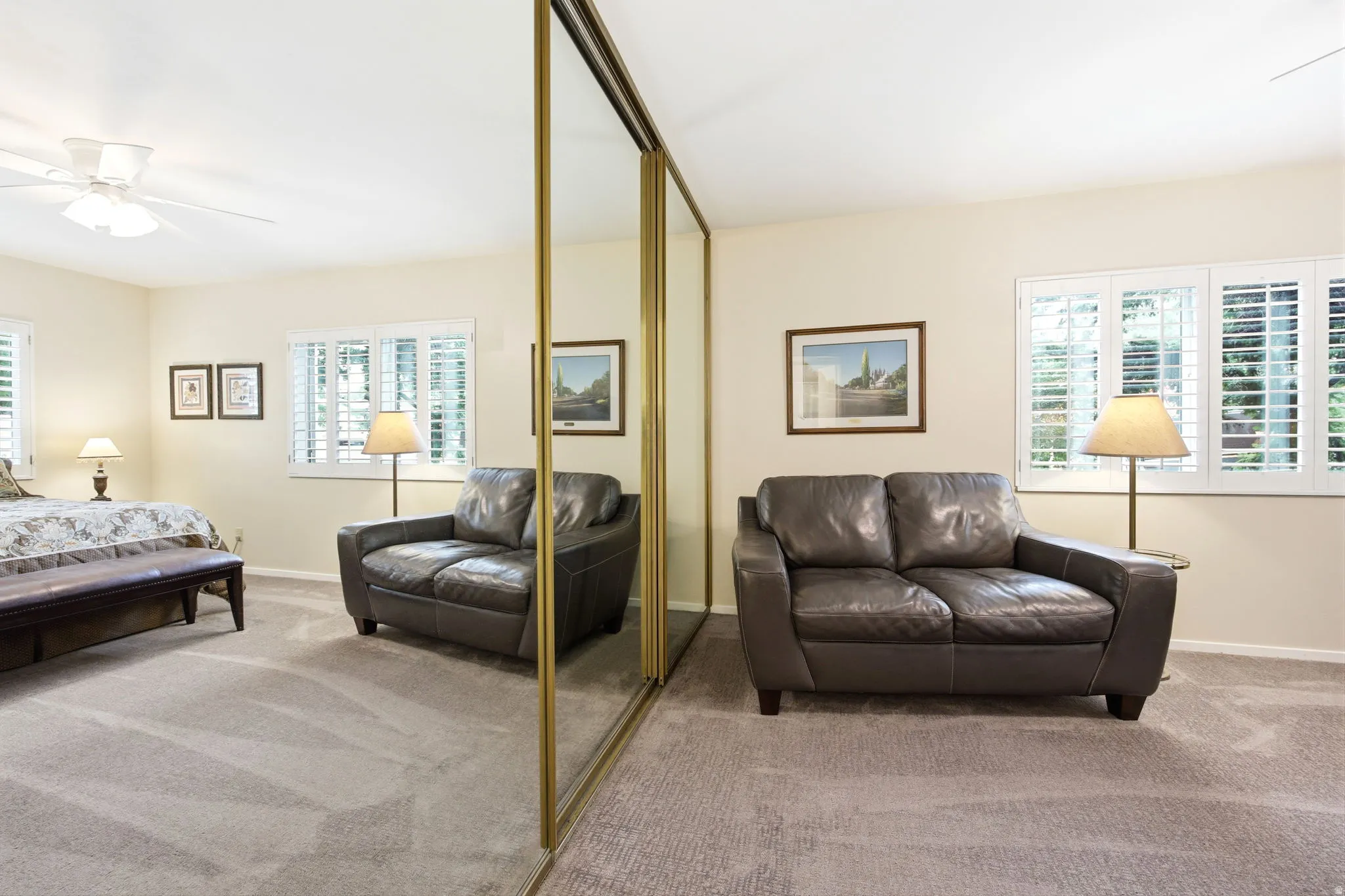 Full wall of mirrored closet doors with gold-finish frames