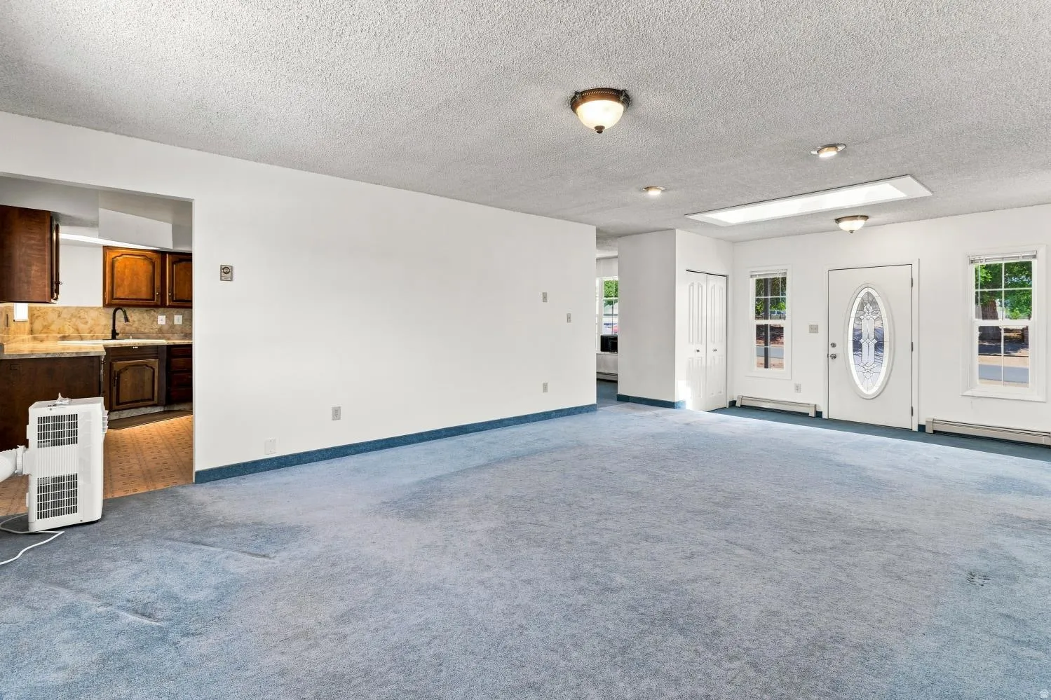 Spacious interior featuring light blue carpeting throughout