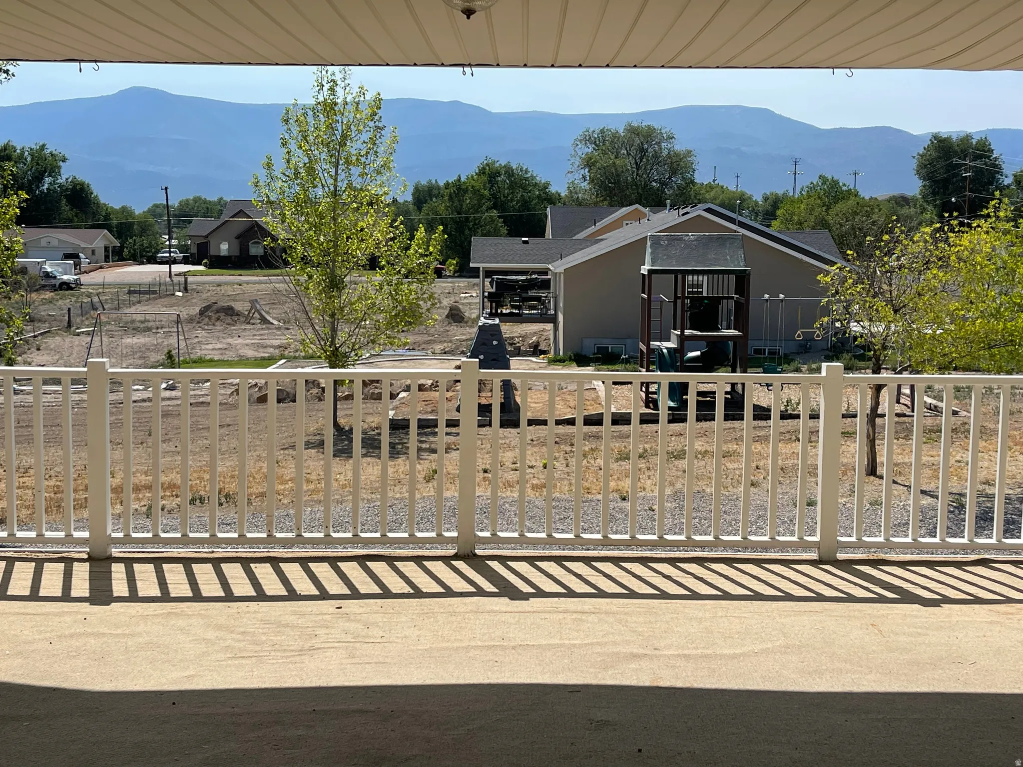 Covered patio with a concrete surface and white railing