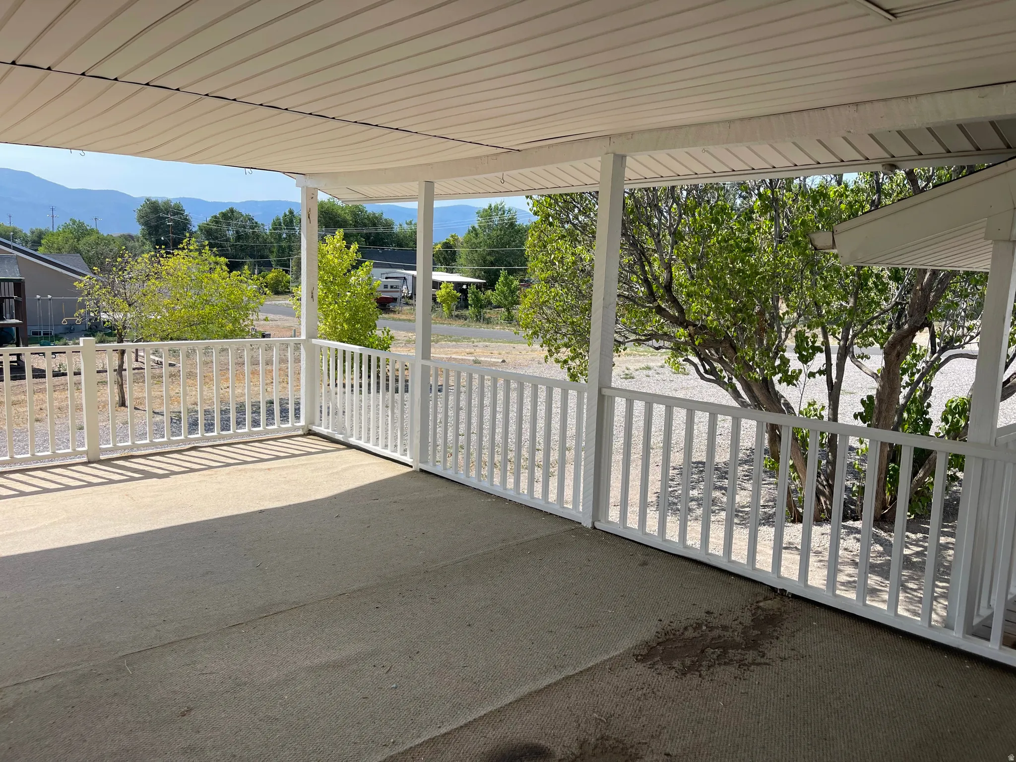 Covered porch with concrete flooring and white railing