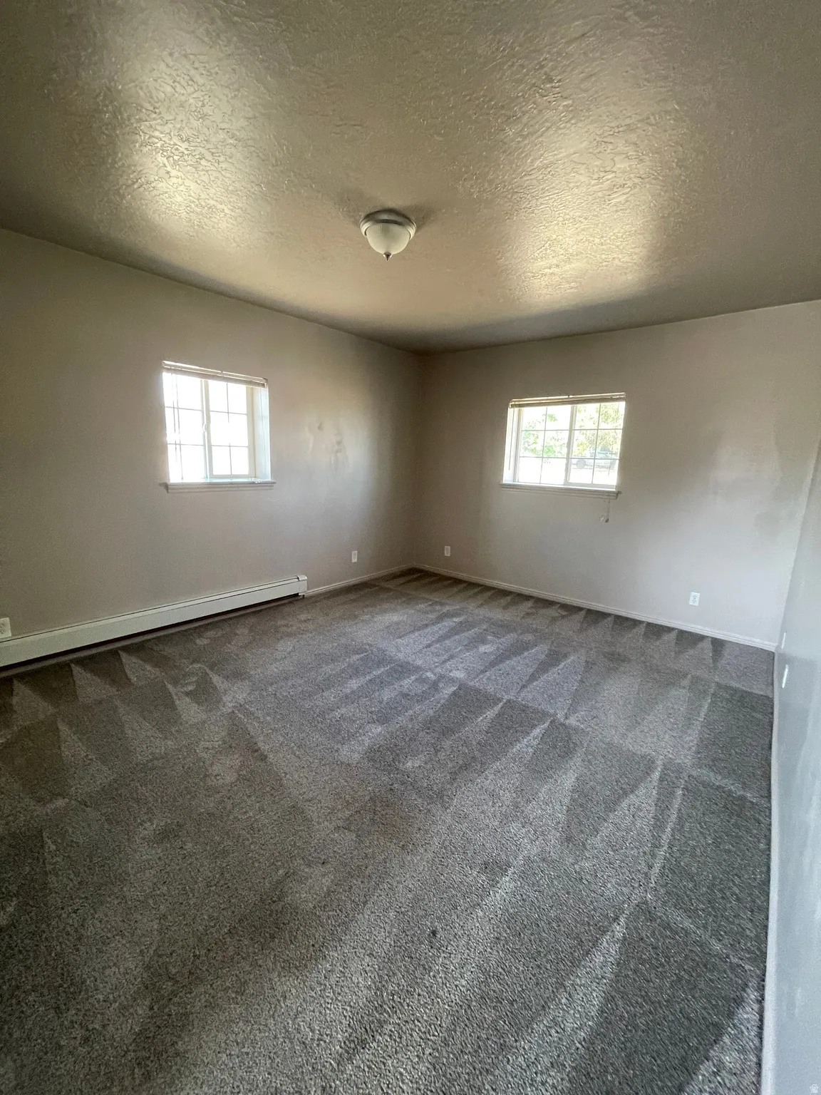 Spacious room featuring neutral carpeting and light-toned walls