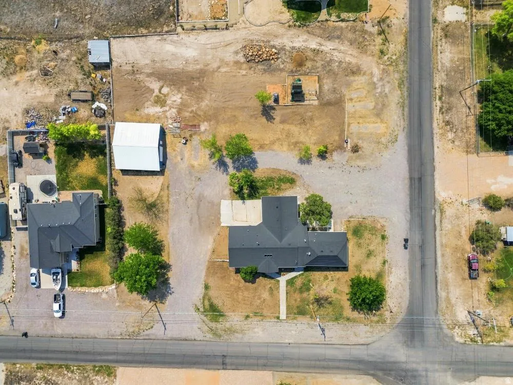 Aerial perspective showcasing a property with extensive land