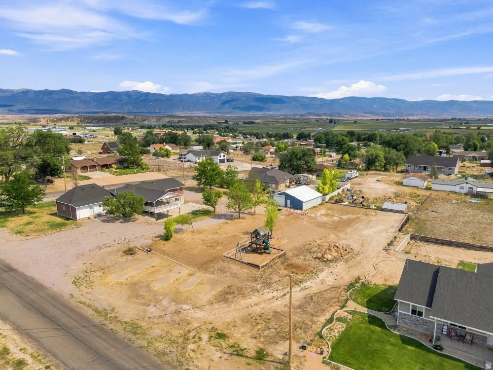 Expansive property featuring a large undeveloped lot, a detached two-car garage, and a multi-level playset