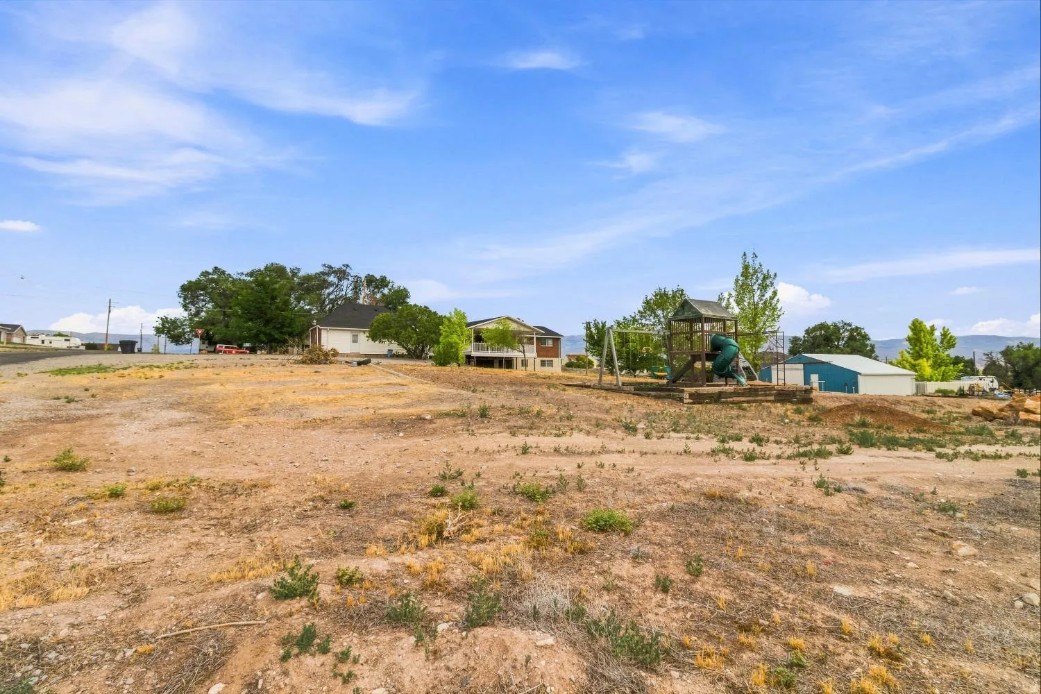 Expansive lot featuring a detached storage building and a recreational structure