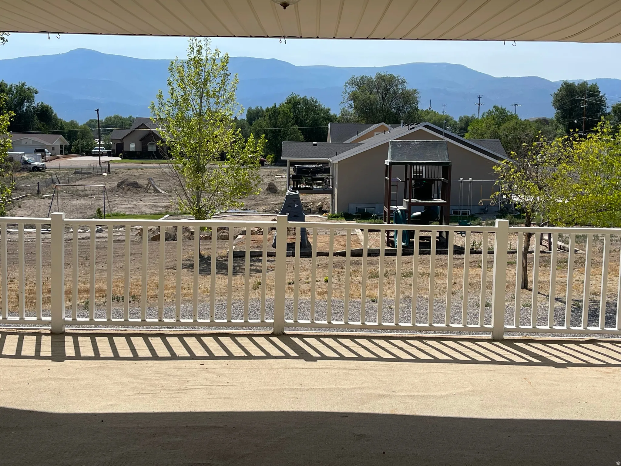 Patio with a white picket railing and a concrete surface