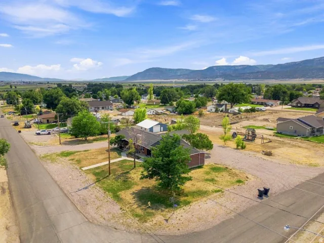 Expansive corner lot featuring a traditional-style residence with a dark roof and a detached garage/shop structure