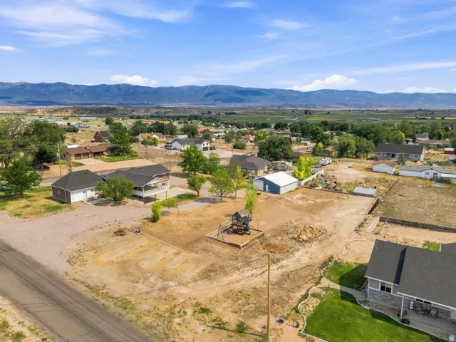 Expansive property featuring a large undeveloped lot, a detached two-car garage, and a multi-level playset