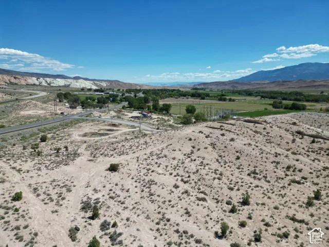 Expansive undeveloped lot featuring a natural desert landscape and distant mountain ranges