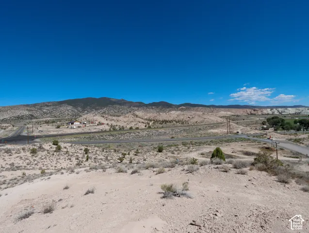 Expansive desert landscape featuring distant mountains and clear blue skies