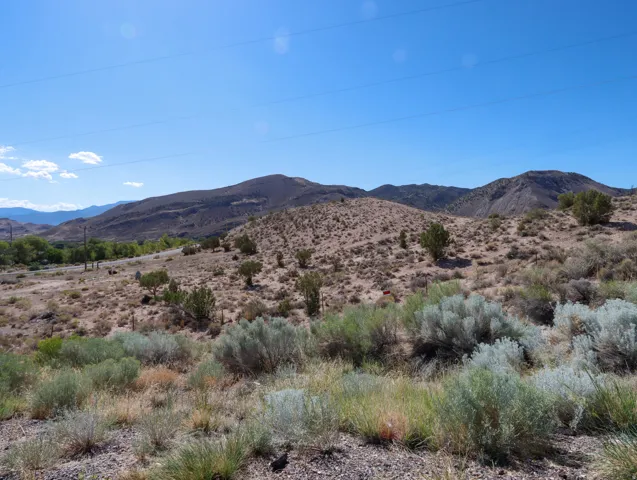 Expansive desert landscape featuring rolling hills and distant mountains
